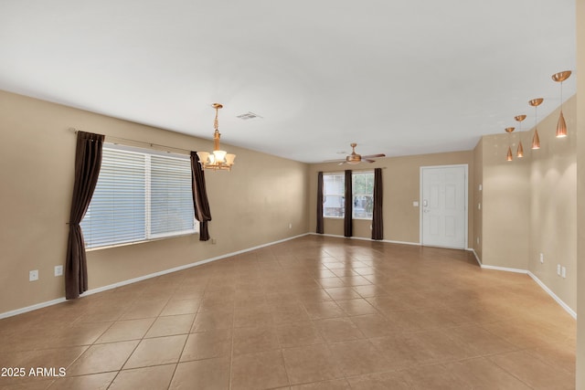 unfurnished room with ceiling fan with notable chandelier, light tile patterned flooring, visible vents, and baseboards