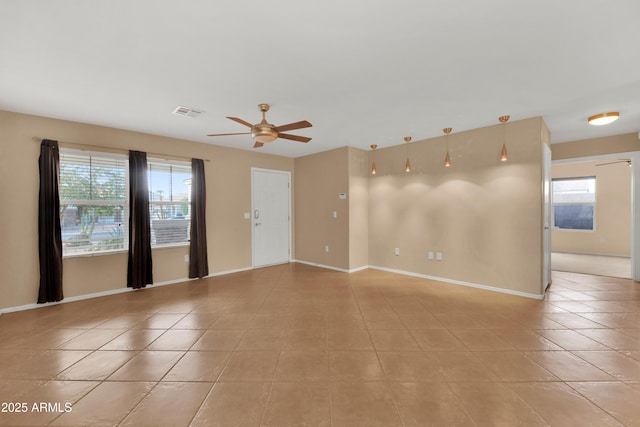 spare room with visible vents, ceiling fan, baseboards, and light tile patterned floors