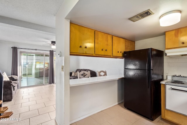 kitchen with backsplash, black fridge, a textured ceiling, ceiling fan, and electric stove