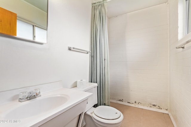 bathroom with tile patterned flooring, vanity, toilet, and walk in shower