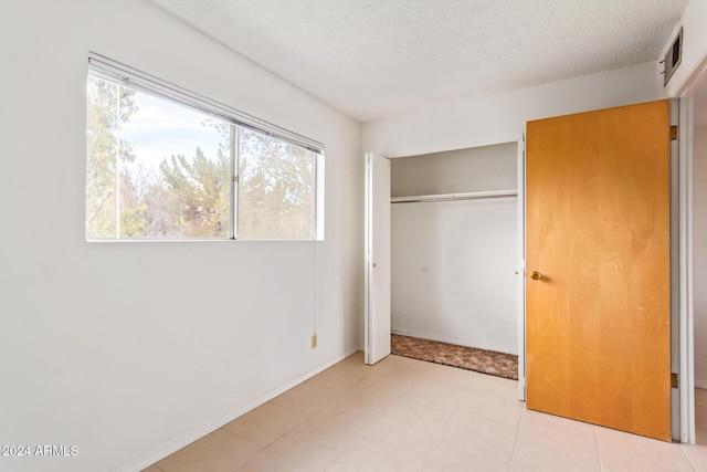 unfurnished bedroom with a closet and a textured ceiling