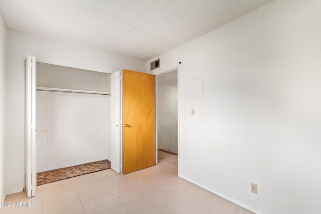 unfurnished bedroom with a textured ceiling and a closet