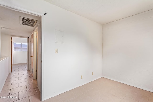 tiled spare room with a textured ceiling