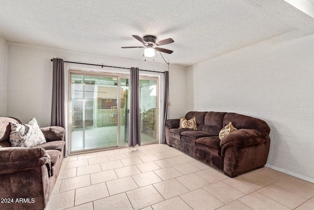 living room featuring ceiling fan, light tile patterned floors, and a textured ceiling