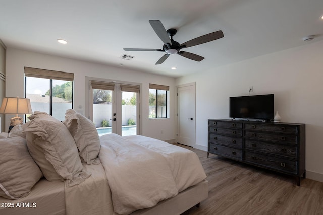 bedroom featuring access to exterior, wood finished floors, french doors, and baseboards