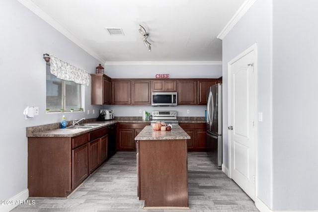 kitchen featuring a center island, crown molding, light wood-type flooring, and stainless steel appliances