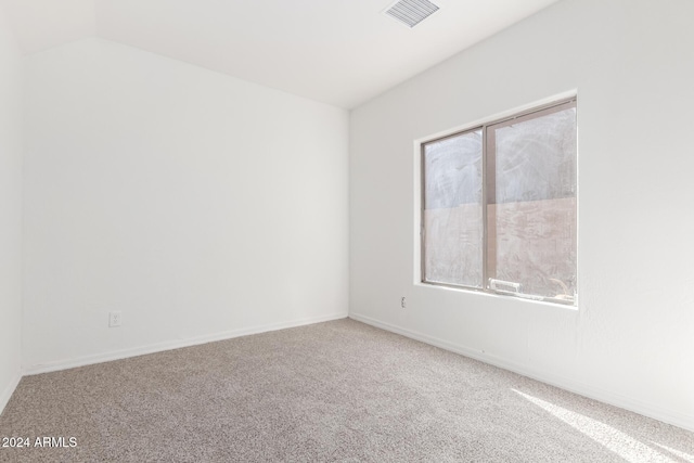 carpeted empty room featuring lofted ceiling and a wealth of natural light