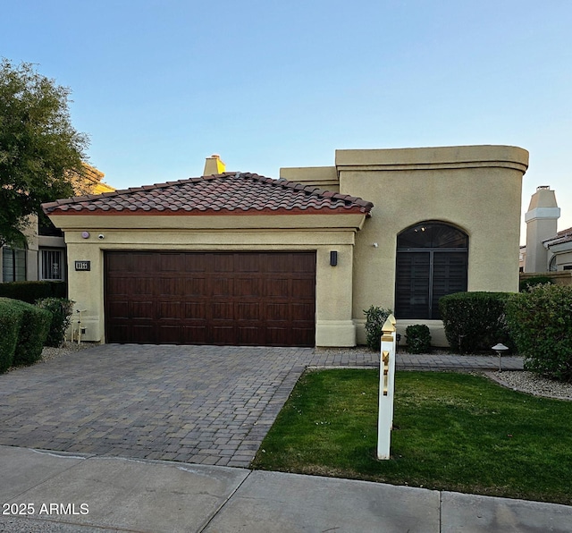 mediterranean / spanish-style home featuring a garage and a front yard