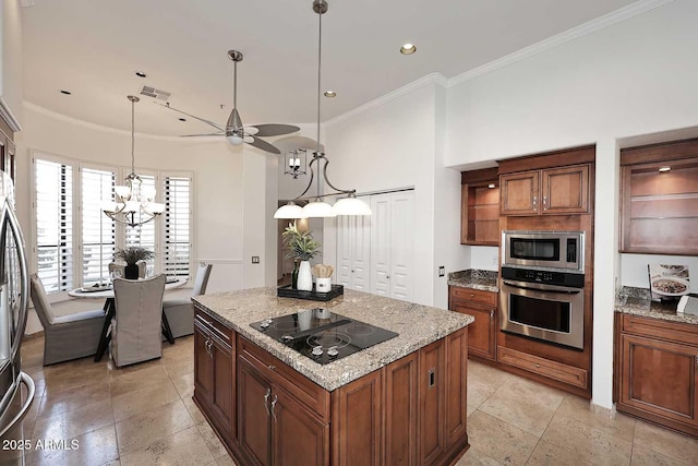 kitchen featuring appliances with stainless steel finishes, ornamental molding, light stone countertops, a kitchen island, and decorative light fixtures