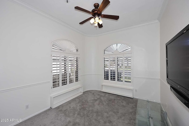 spare room featuring dark carpet, ornamental molding, and ceiling fan