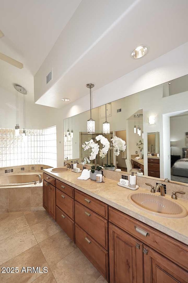 bathroom with vanity, tiled bath, and tile patterned floors