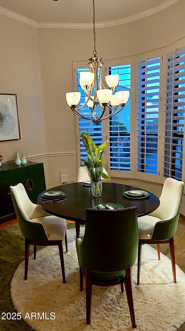 dining space featuring crown molding and a chandelier