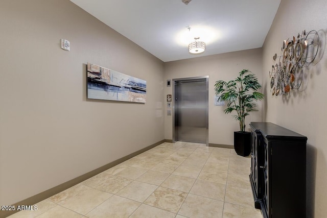 hall featuring light tile patterned floors and elevator