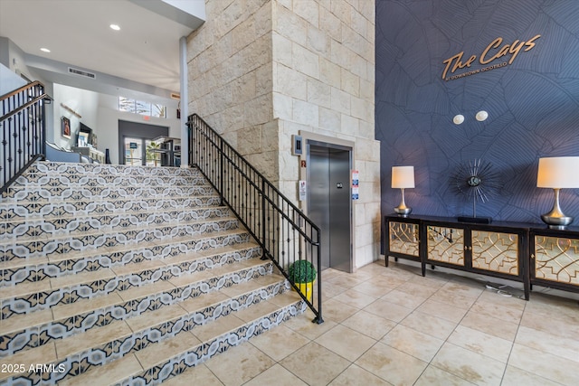 stairs featuring tile patterned floors and elevator