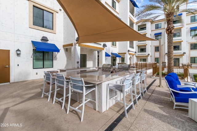 view of patio / terrace with exterior bar, an outdoor kitchen, and area for grilling