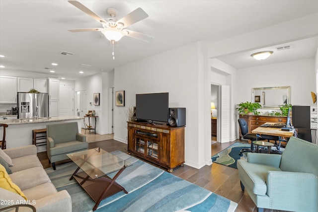 living room with dark hardwood / wood-style flooring and ceiling fan