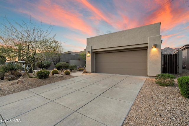 view of front of home with stucco siding, a garage, and concrete driveway