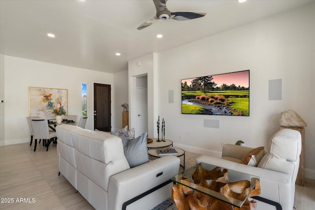 living room featuring baseboards, ceiling fan, and recessed lighting