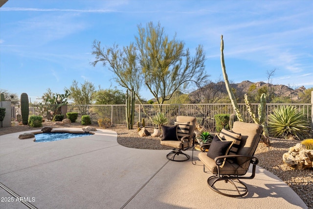 view of patio featuring fence and a mountain view