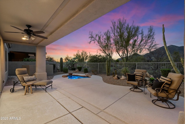 view of patio / terrace with a fenced backyard, a mountain view, and a ceiling fan
