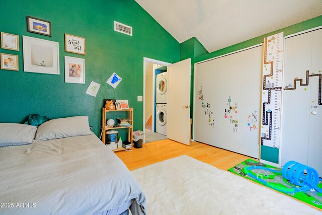 8111 W Wacker Rd Unit 62, Peoria, AZ 85381 - bedroom featuring estacked washer and dryer, wood finished floors, and lofted ceiling