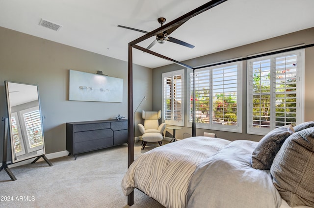 bedroom with ceiling fan, multiple windows, visible vents, and light colored carpet