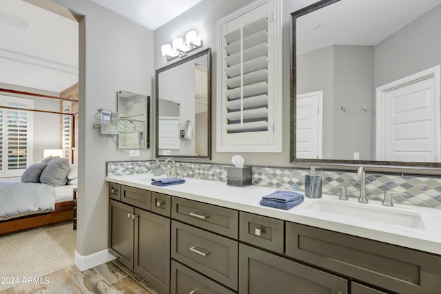 full bathroom featuring ensuite bathroom, a sink, visible vents, decorative backsplash, and double vanity