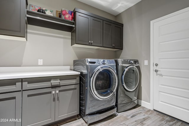 laundry area with cabinet space, washing machine and dryer, and baseboards