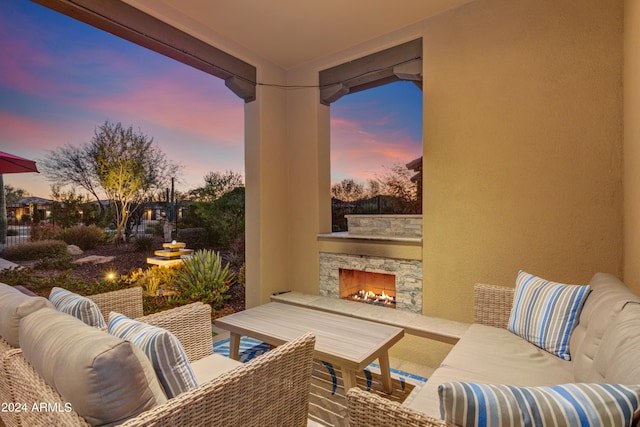 patio terrace at dusk featuring an outdoor living space with a fireplace