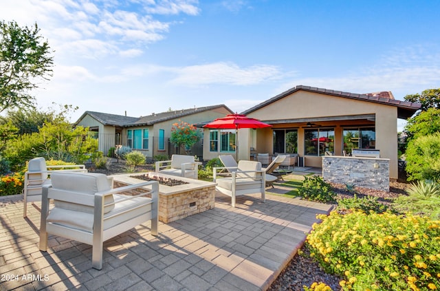 exterior space with a fire pit, a patio, a bar, and stucco siding