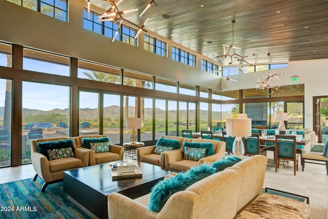 sunroom / solarium with wood ceiling, a chandelier, and a mountain view