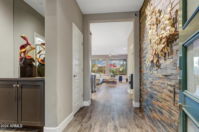 corridor with baseboards and wood finished floors