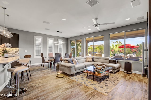 living area with plenty of natural light, visible vents, and light wood-style floors