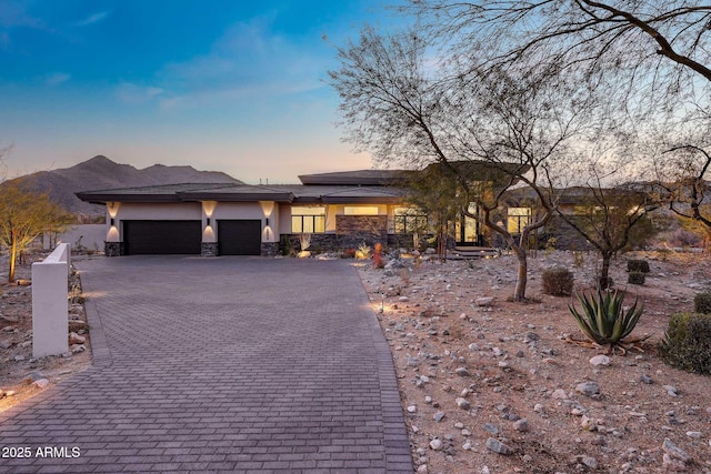 prairie-style house featuring a garage and a mountain view