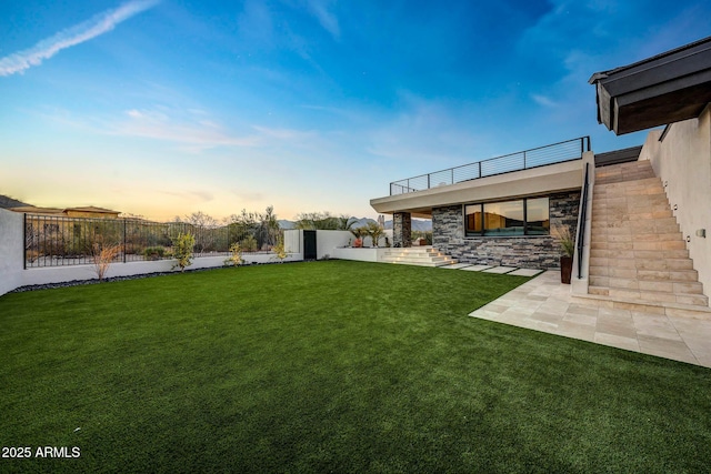 yard at dusk featuring a patio area