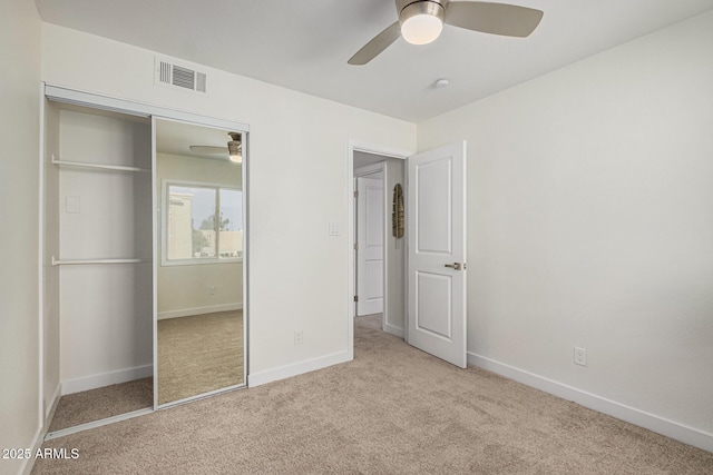 unfurnished bedroom with ceiling fan, a closet, and light carpet