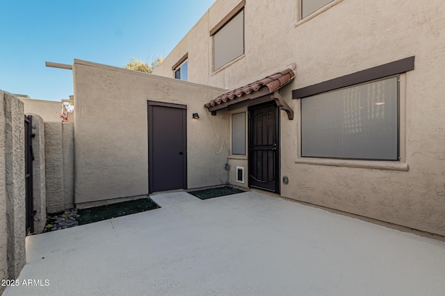 view of exterior entry featuring a patio