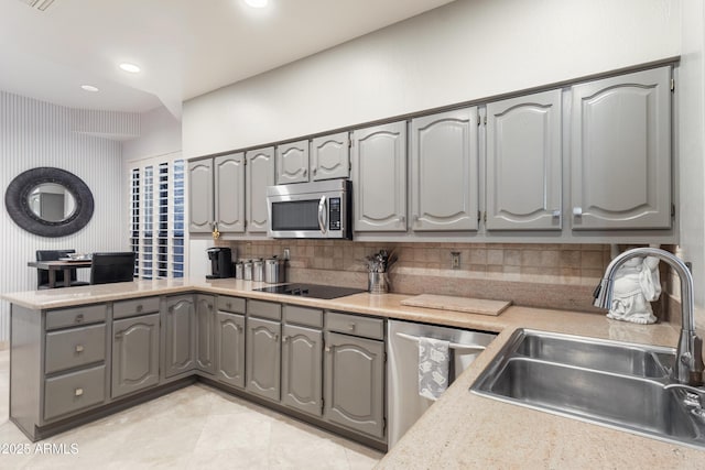 kitchen with appliances with stainless steel finishes, sink, gray cabinetry, and backsplash