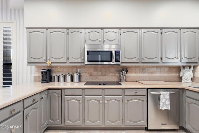 kitchen featuring backsplash, appliances with stainless steel finishes, and gray cabinetry