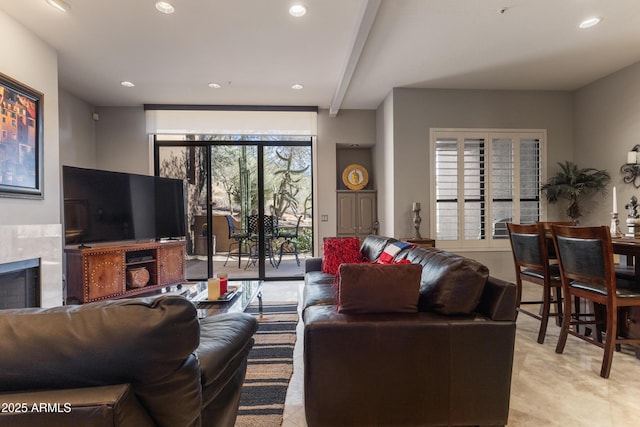 living room featuring beamed ceiling and a fireplace