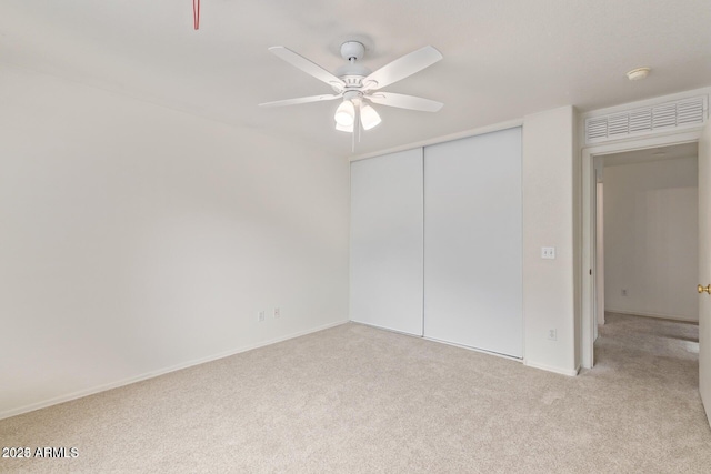 unfurnished bedroom featuring a closet, carpet, ceiling fan, and baseboards