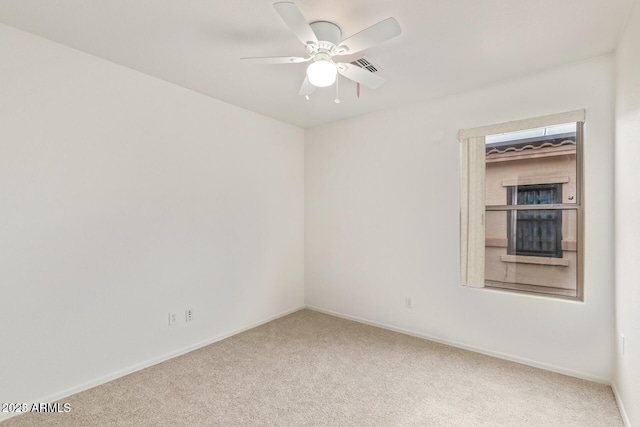 carpeted empty room with visible vents, baseboards, and ceiling fan