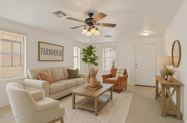 living room with light colored carpet, ceiling fan, and visible vents
