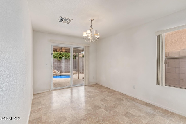 empty room with a notable chandelier, visible vents, and baseboards