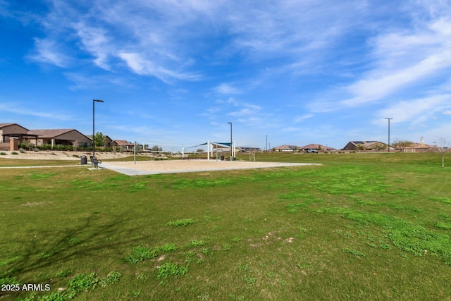 view of home's community featuring volleyball court and a yard