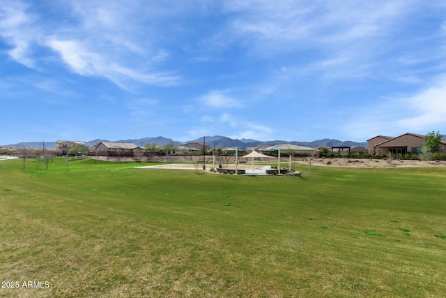 view of home's community with a mountain view and a yard