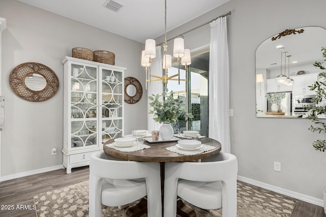 dining area featuring dark hardwood / wood-style floors and a notable chandelier