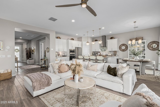 living room featuring ceiling fan with notable chandelier