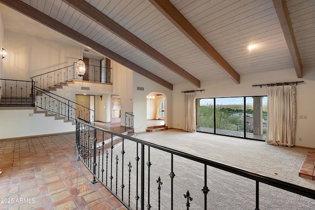 6349 E Hummingbird Ln, Paradise Valley, AZ 85253 - unfurnished living room featuring high vaulted ceiling, arched walkways, a wood ceiling with exposed beams, and stairway