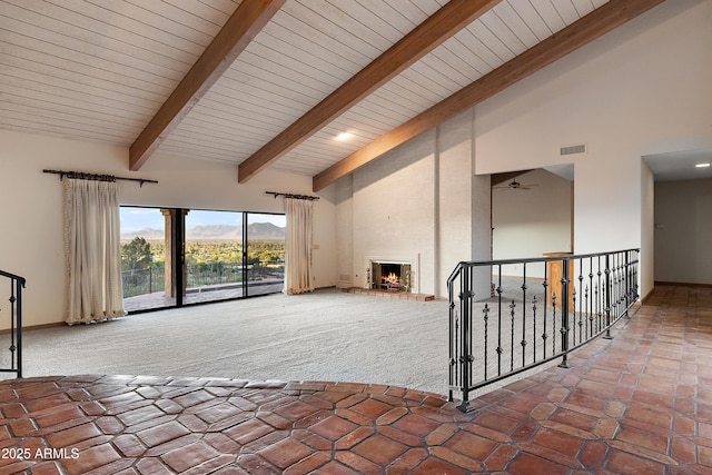 6349 E Hummingbird Ln, Paradise Valley, AZ 85253 - unfurnished living room featuring high vaulted ceiling, carpet floors, ceiling fan, a large fireplace, and a wooden ceiling with exposed beams